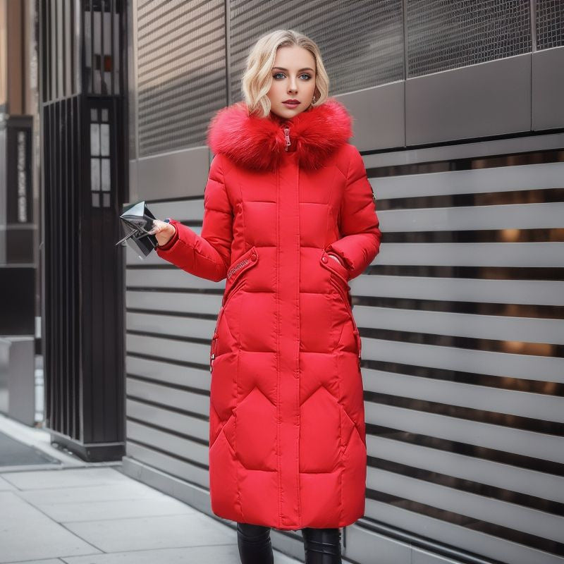 A woman wears a long red quilted puffer coat featuring a large faux fur hood collar.