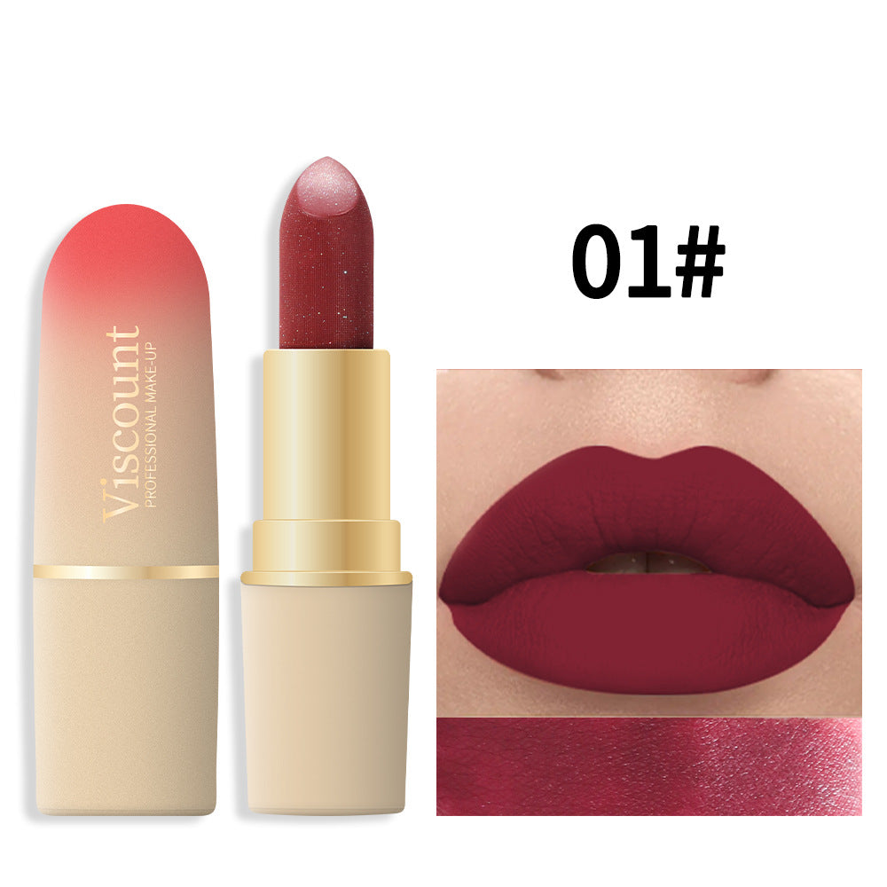Metallic gold and pink ombre matte lipstick tube with Viscount logo, beside dark red lipstick swatch and lips.