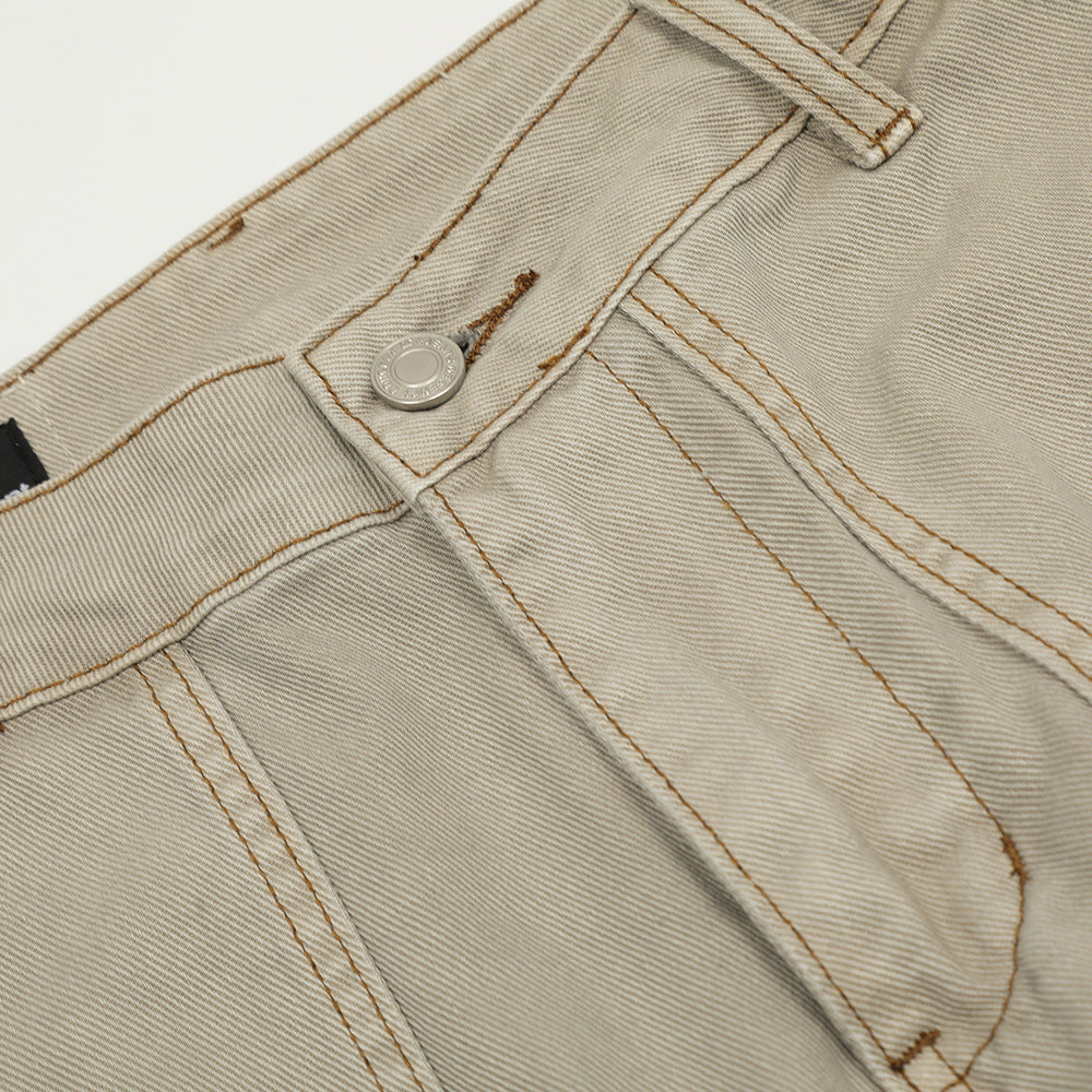 Beige denim pants with a solid pattern, visible topstitching, belt loops, and a silver metal button.