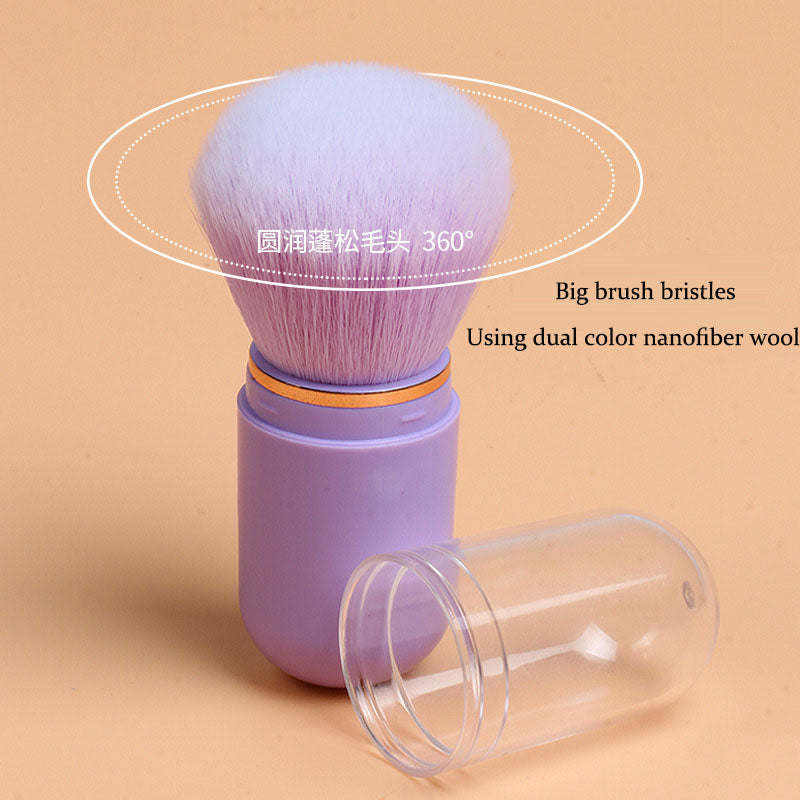Purple cosmetic brush with soft, dense bristles in a matching purple capsule case with a clear cap.