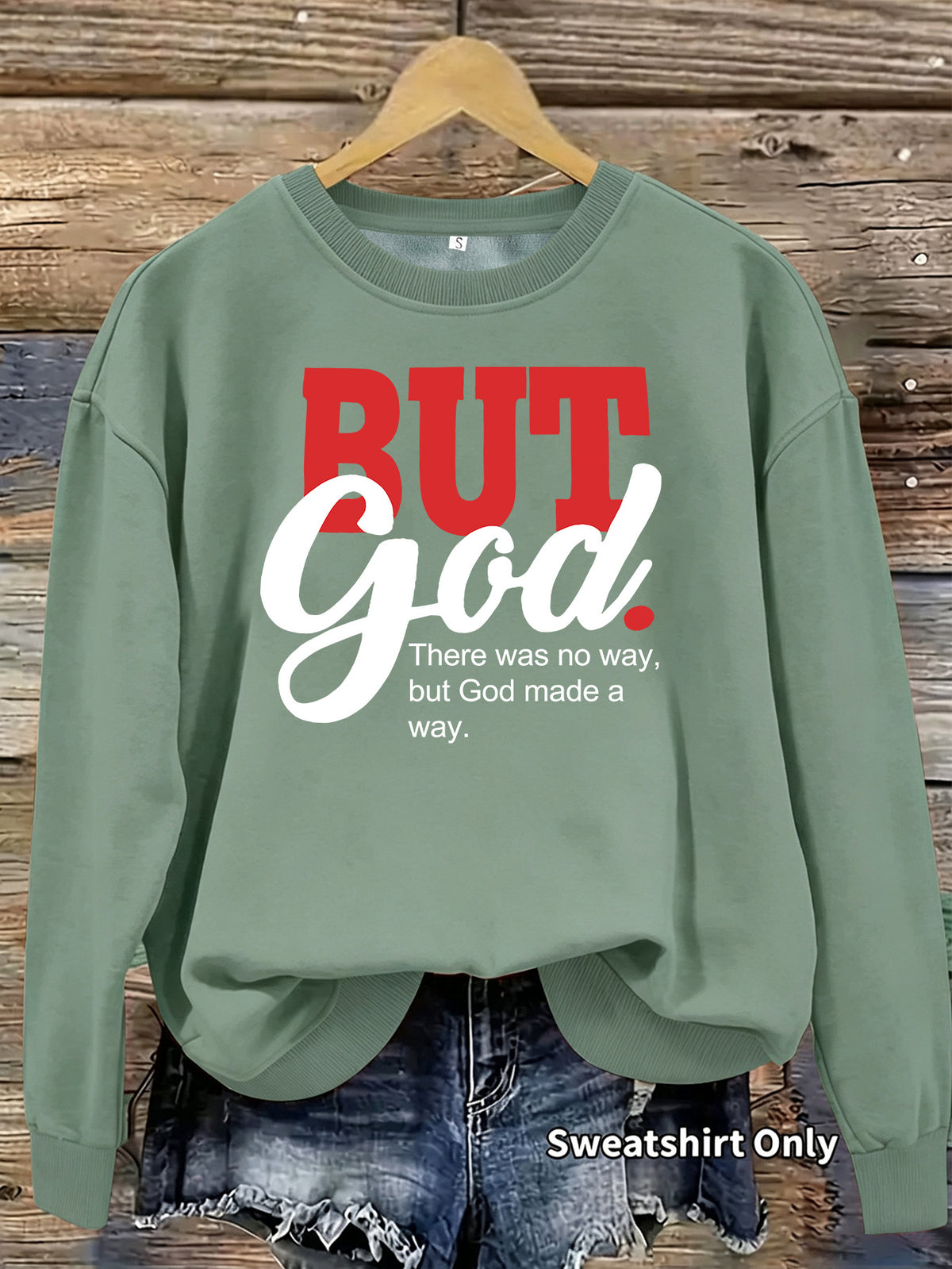 Green crewneck sweatshirt featuring "BUT GOD" in red and white text, and "There was no way, but God made a way."