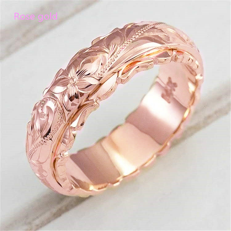 Rose gold band ring featuring an intricate Hawaiian floral and scroll carved pattern.