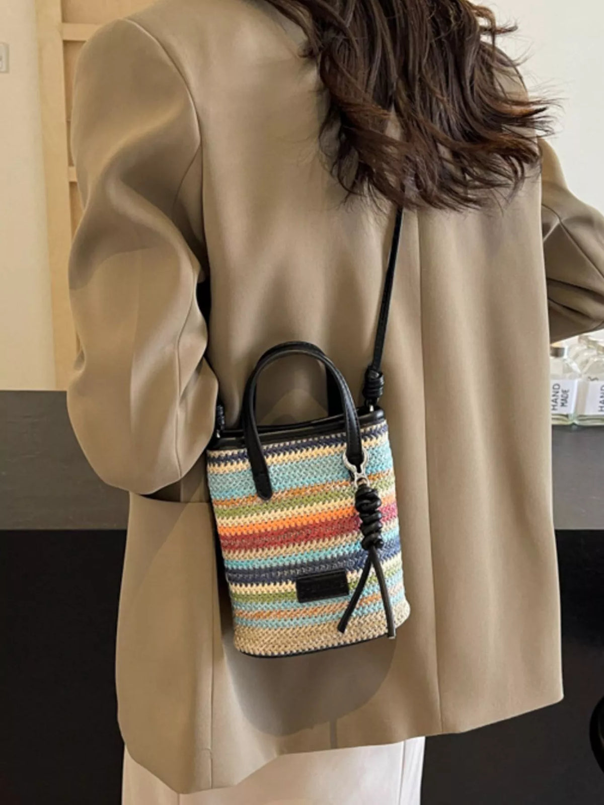 Striped woven mini crossbody bag from Plush Fashion Hub with adjustable strap and colorful pattern.
