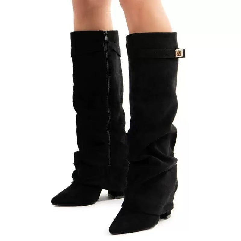 Black slouchy knee-high boots in faux suede, featuring a pointed toe, side zipper, and buckle detail.