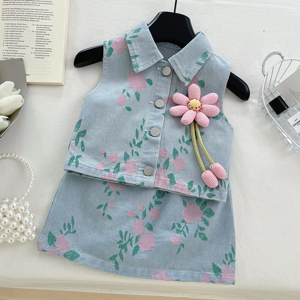 Light blue denim vest and skirt set with pink floral pattern, buttons, and a large plush flower pin.