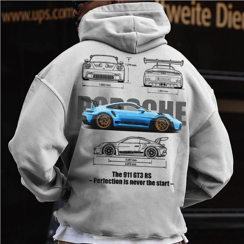 A man wearing a grey hoodie with a Porsche 911 GT3 RS graphic and text on the back.