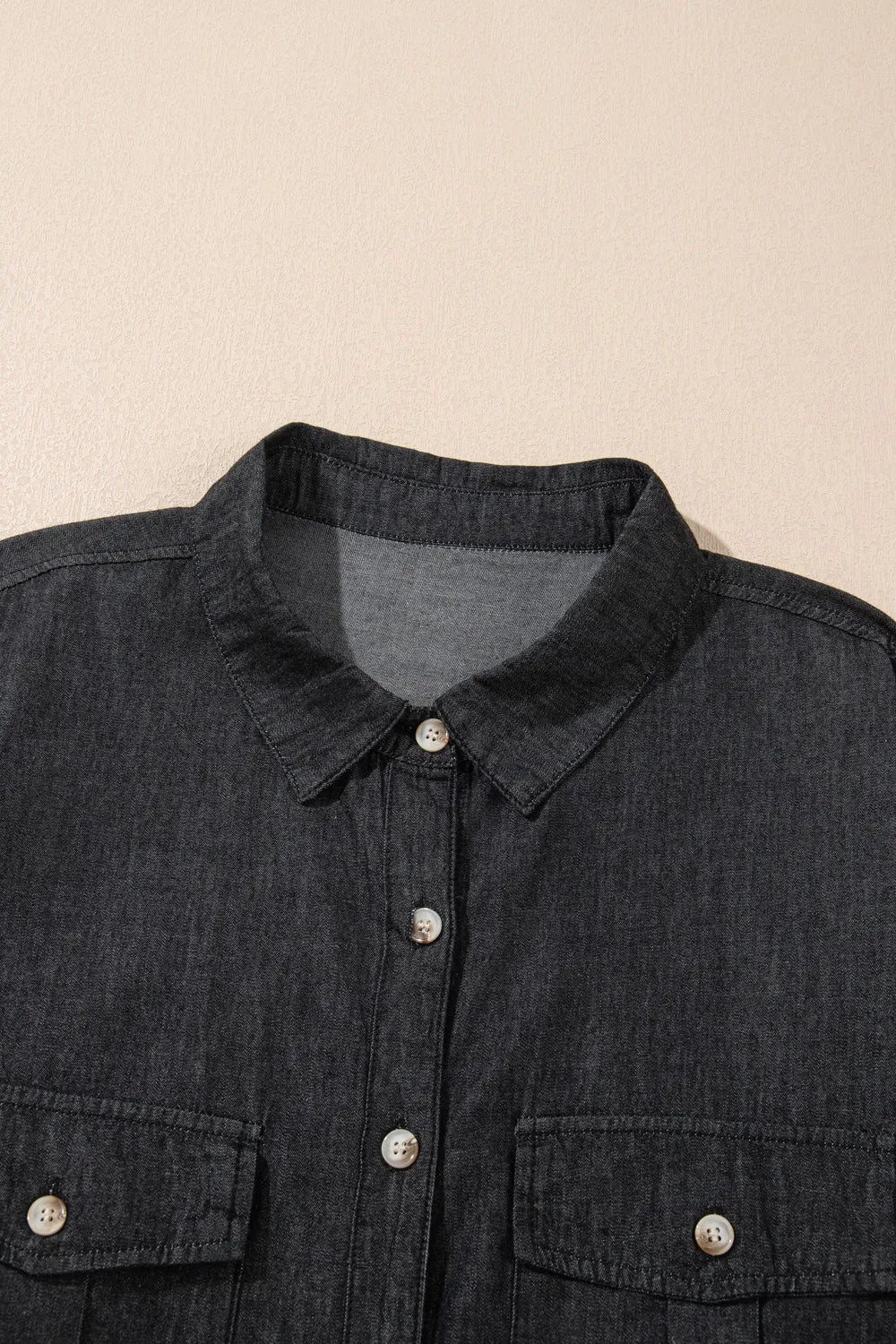 Denim top with long sleeves, collared neck, and front pockets, featuring a trendy denim design by Trendsi.