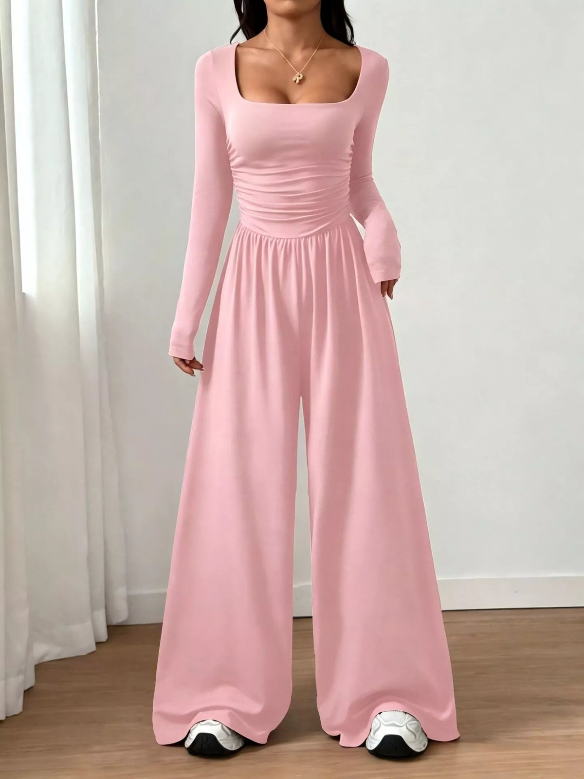 Black ruched square neck wide-leg jumpsuit from Trendsi, featuring a fitted bodice and flowy pant legs, stylish and comfortable.