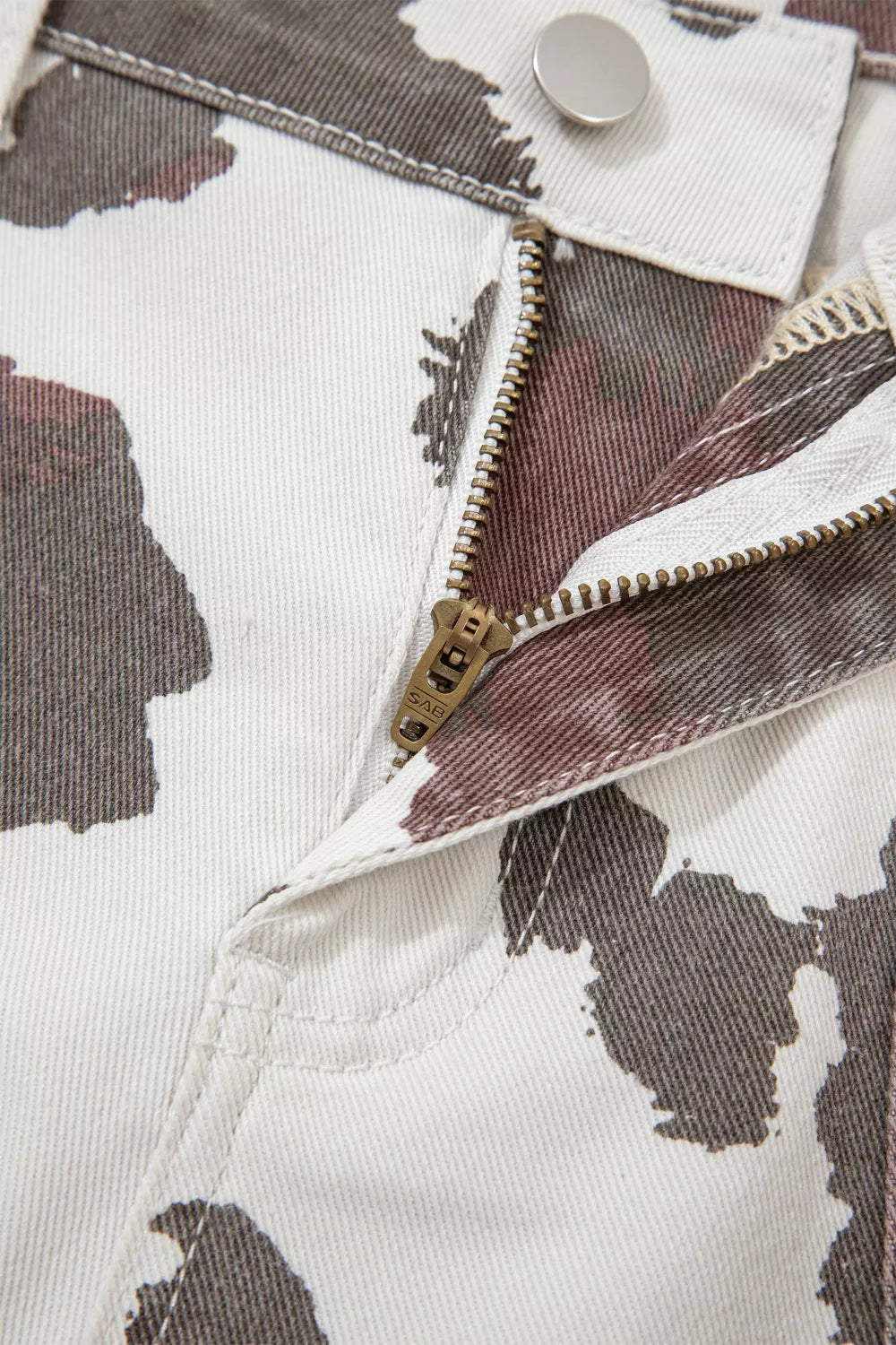 Cow spots printed Plush Fashion Hub jeans with multiple pockets, featuring a stylish and trendy design on denim.