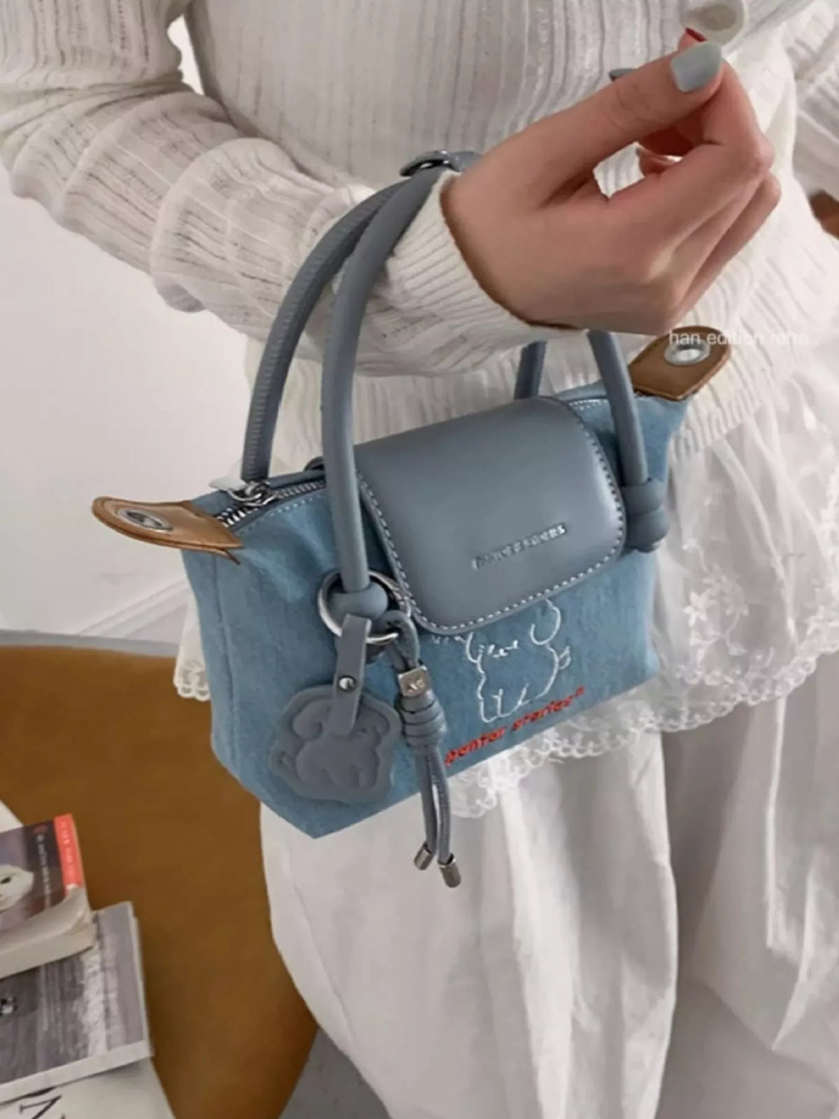 Plush Fashion Hub puppy embroidered denim handbag with adjustable shoulder strap and front zipper pocket.