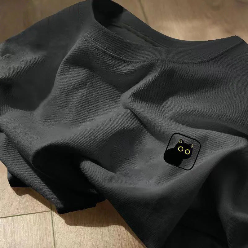 A folded dark grey cotton t-shirt with a small black cat graphic on the chest.