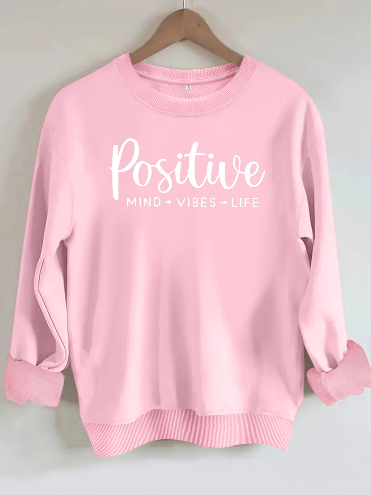 Light pink cotton blend crewneck sweatshirt featuring "Positive MIND VIBES LIFE" text in white across the chest.