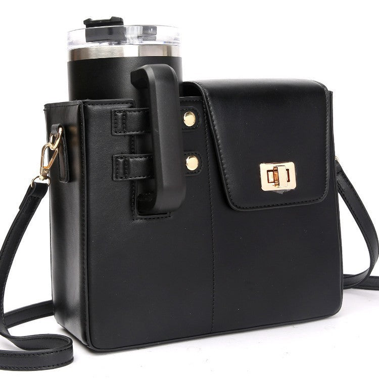 Black leather crossbody bag with a built-in black tumbler holder holding a black tumbler with a clear lid.