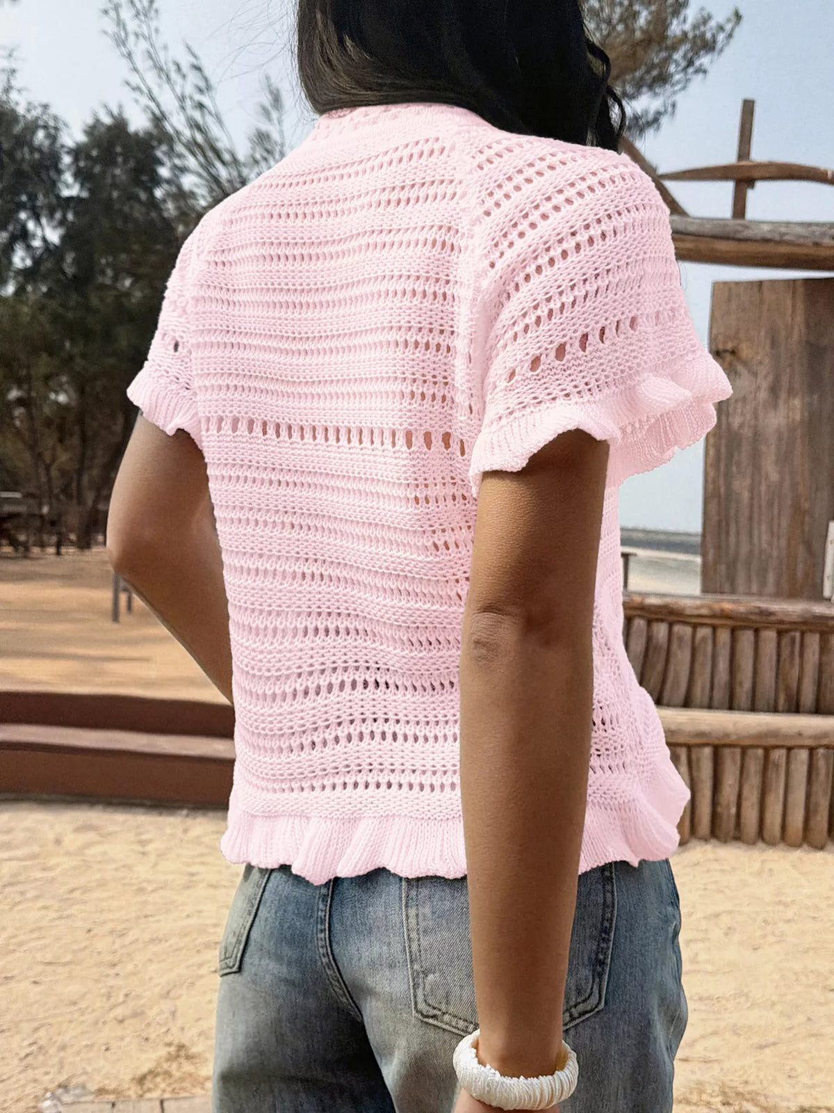 Openwork ruffled hem knit top by Plush Fashion Hub featuring a stylish design and textured fabric in a close-up view.