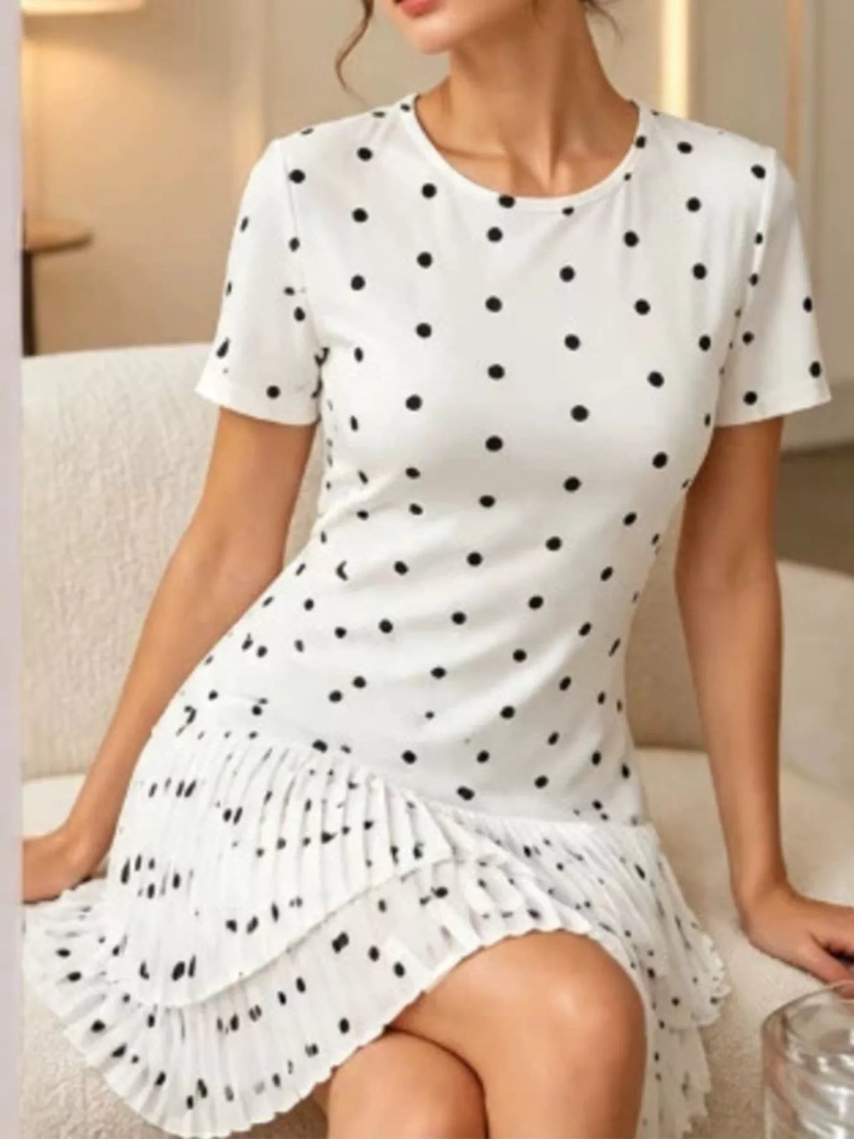 Polka dot pleated hem mini dress by Trendsi, featuring a stylish sleeveless design and playful polka dot pattern suitable for summer.