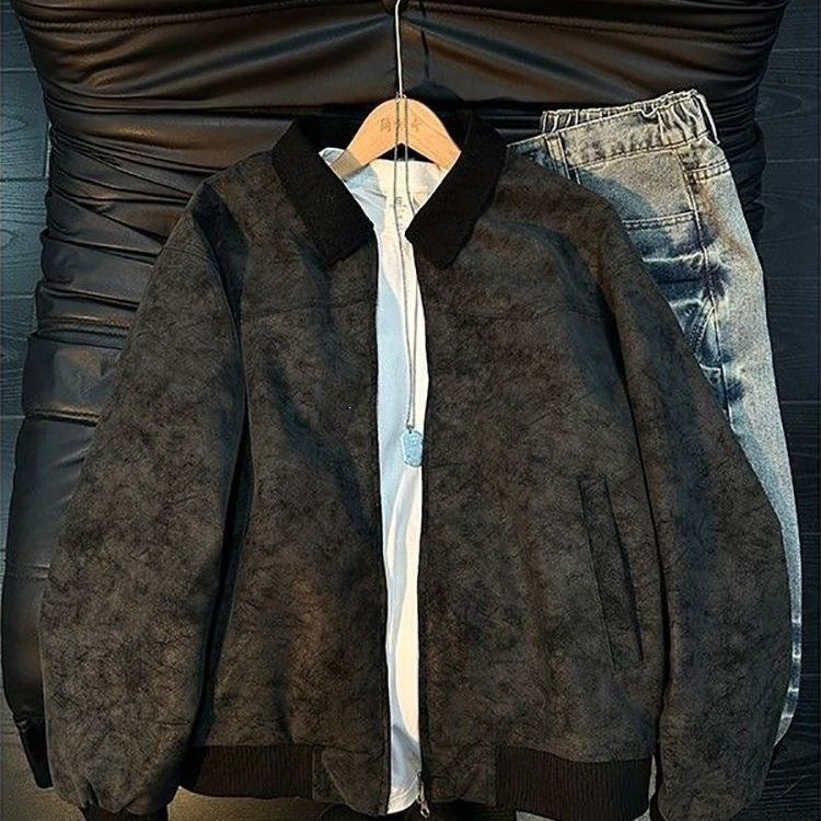 Black faux-suede bomber jacket with collar and ribbed hem over white tee, next to blue jeans.
