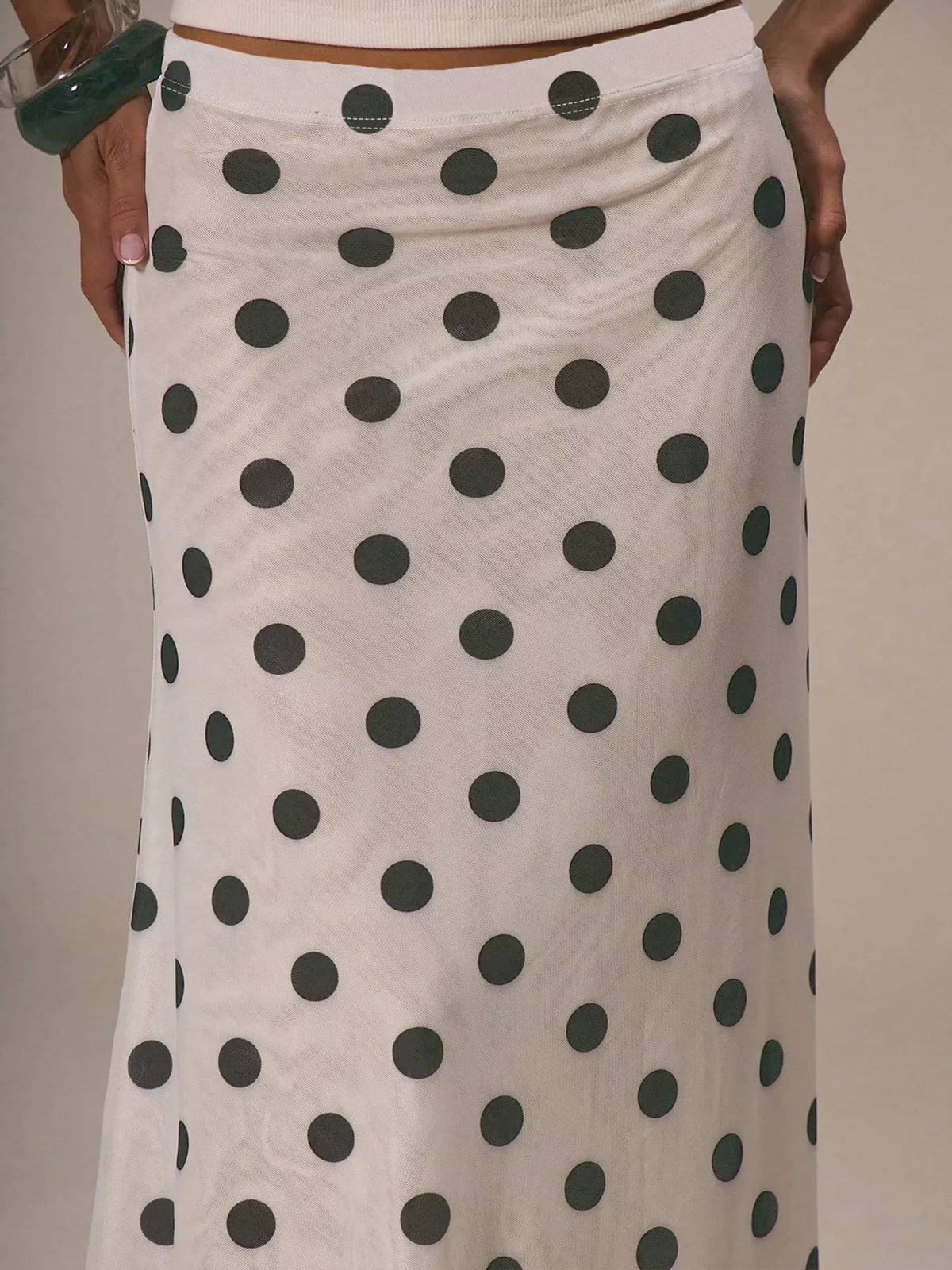 Women's polka dot midi skirt by Plush Fashion Hub, vintage-inspired high-waisted A-line skirt with classic pattern and flowing silhouette.