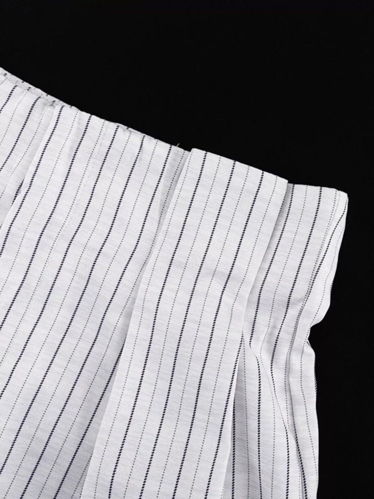 Pinstripe cropped blazer and pleated shorts set by Trendsi, featuring tailored blazer and stylish matching shorts.
