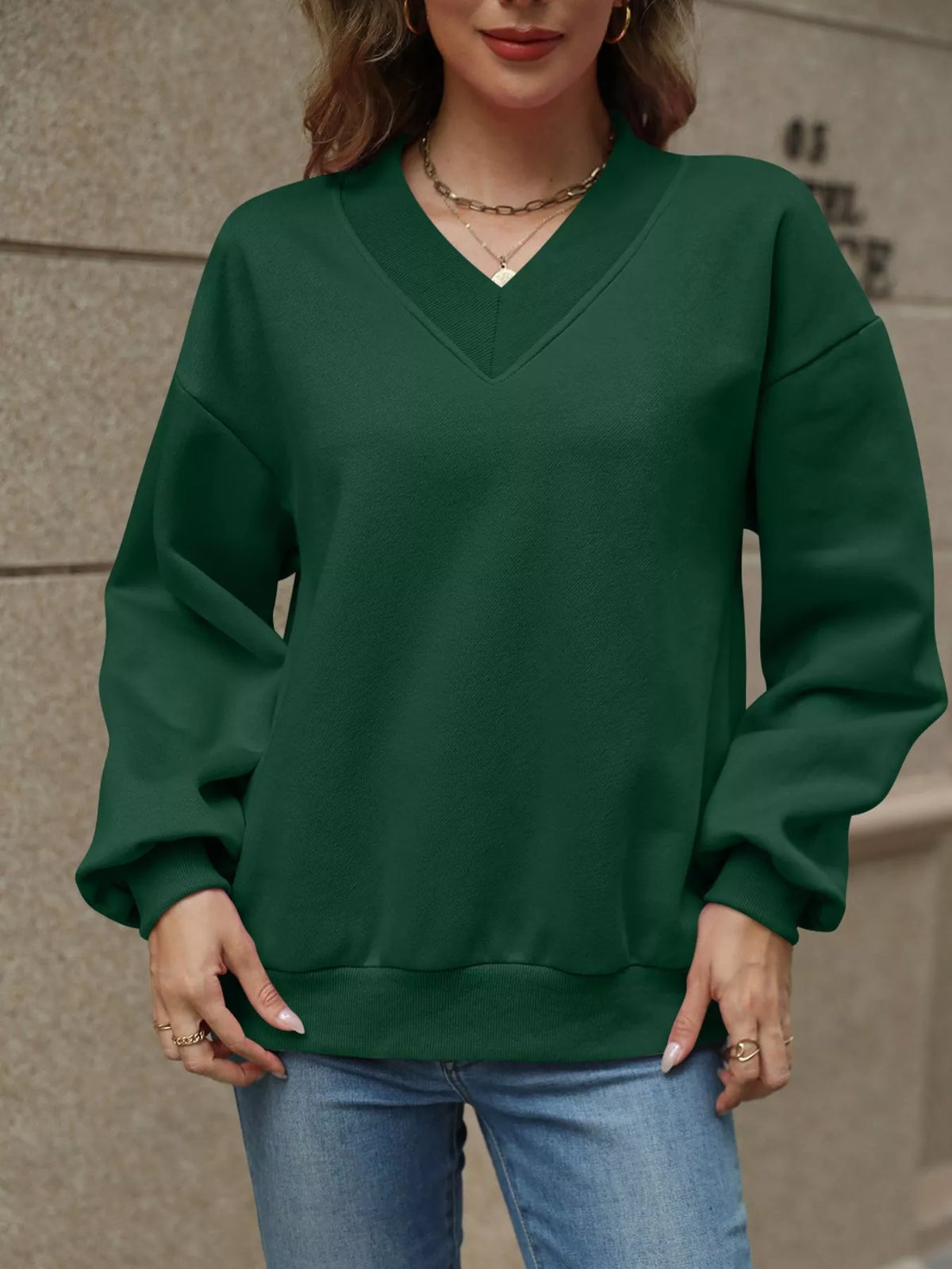 V-neck solid color casual sweatshirt by Trendsi, showcasing a comfortable fit and soft fabric in a relaxed style.
