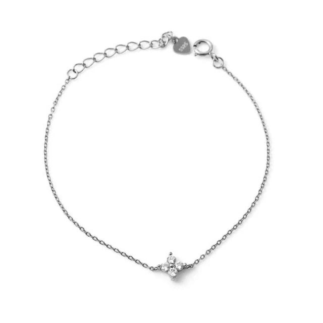 Silver chain bracelet with a dainty four-petal flower charm inset with clear crystals, adjustable clasp, and heart tag.