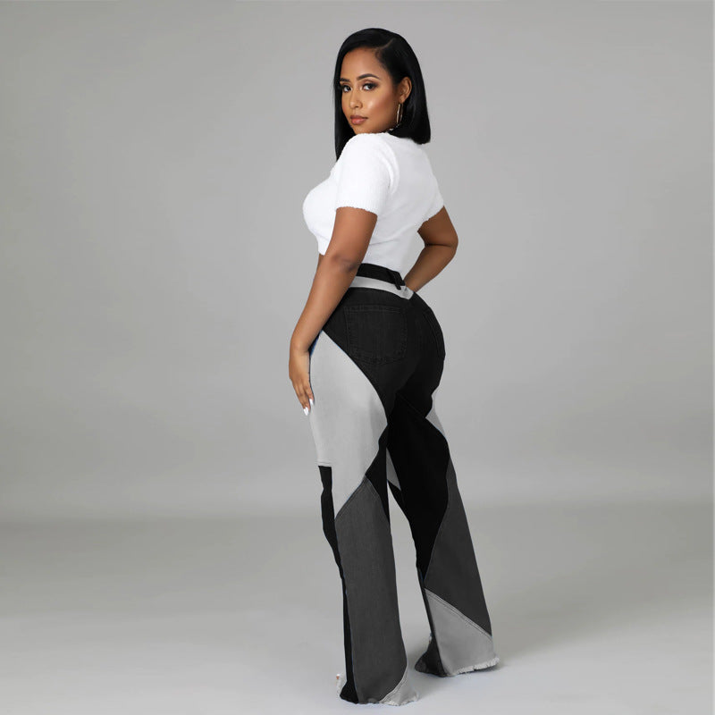 A woman wearing black, gray, and white denim colorblock jeans paired with a white short-sleeve crop top.