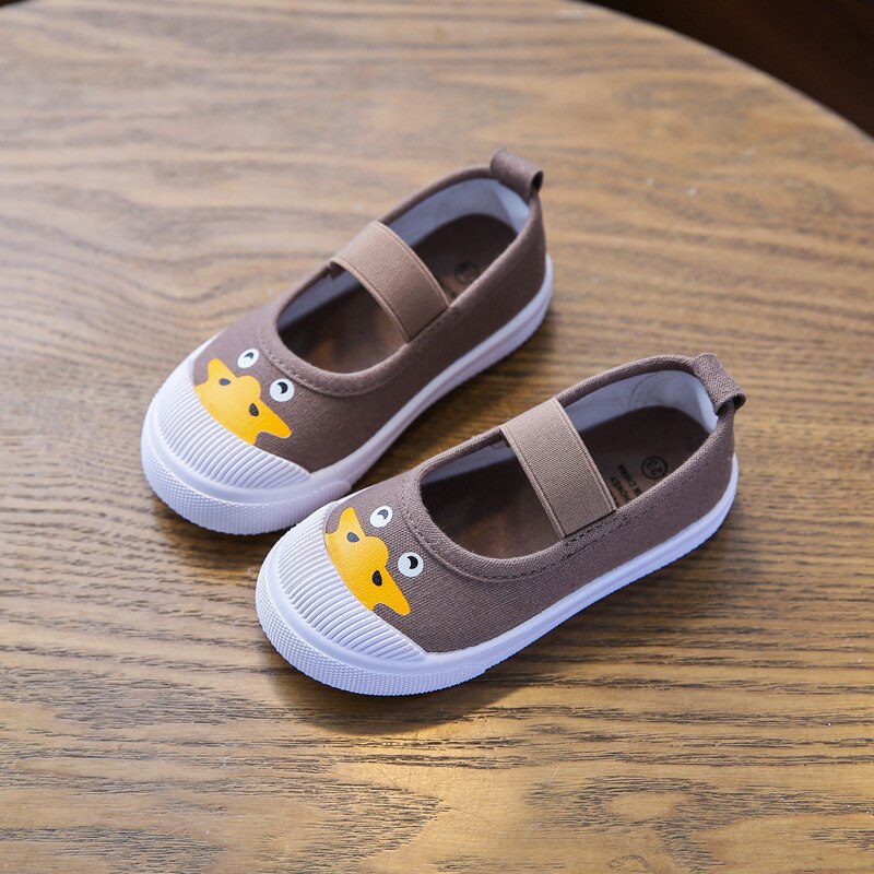 Brown canvas children's slip-on shoes with elastic straps, white rubber soles, and a yellow duck face on the toe.