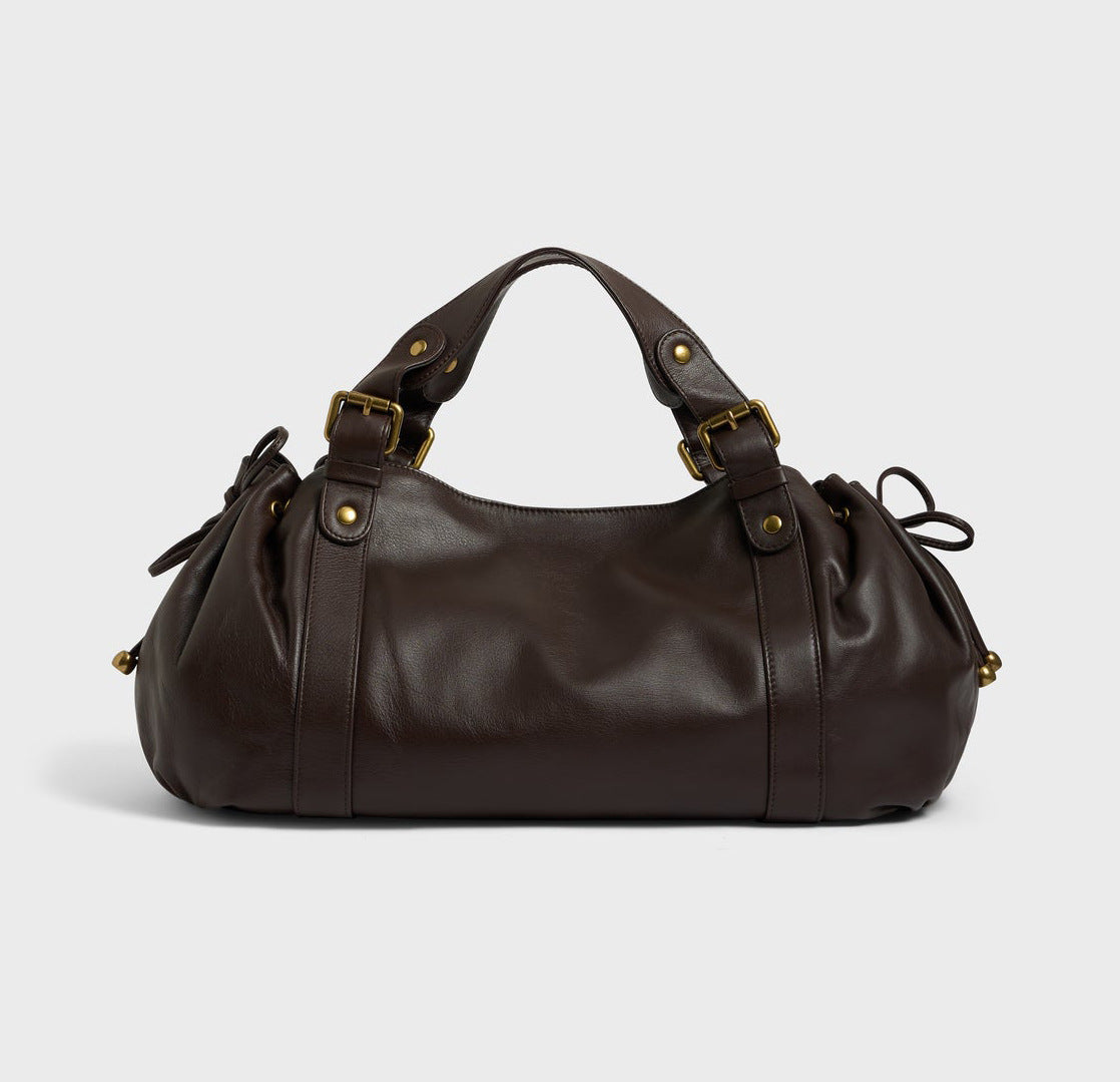 Dark brown leather hobo bag with slouchy style, gold-tone buckles, studs, and drawstring sides.