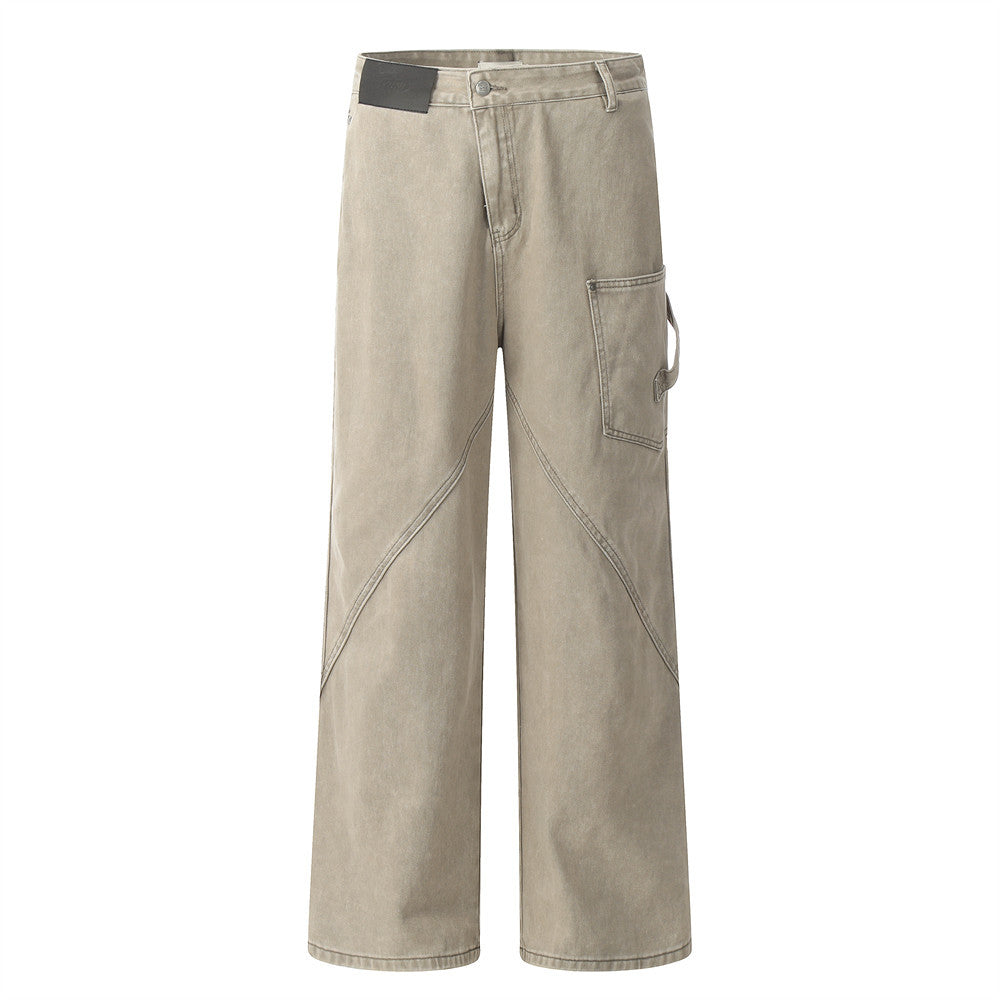 Taupe denim carpenter pants featuring a relaxed straight-leg style, side utility pocket, and diagonal seam details.