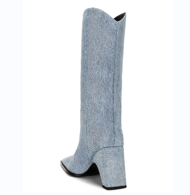Light blue denim knee-high boot with a thick block heel and pointed toe, viewed from the rear.