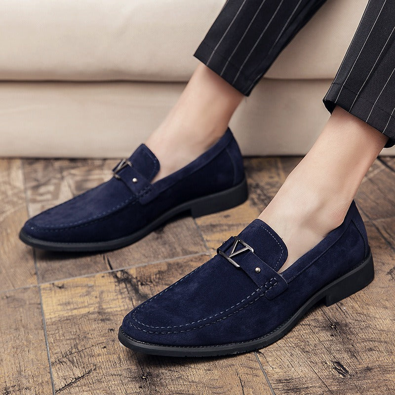 Navy blue suede loafers with a metallic V-buckle accent and contrasting stitching.