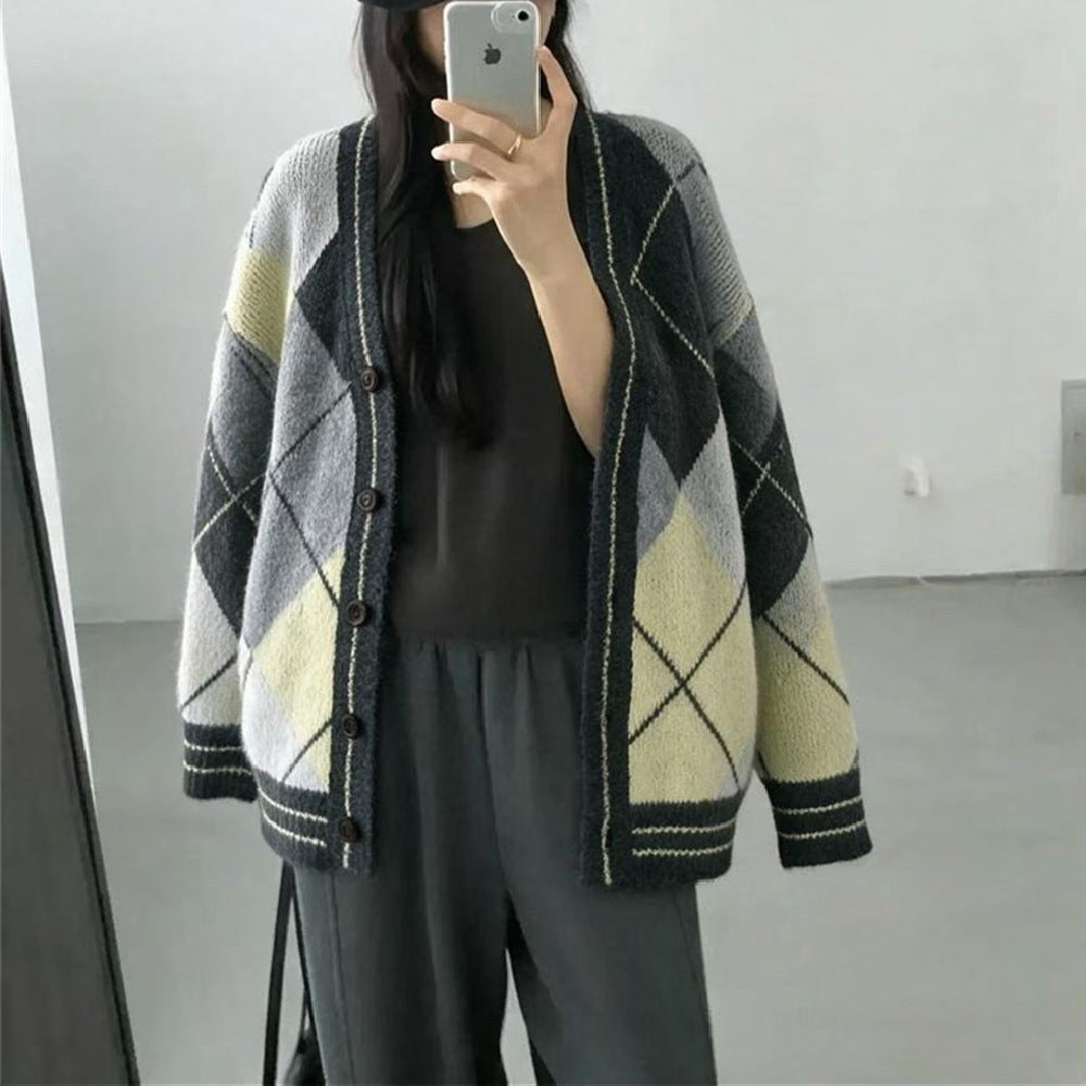 A person wearing a grey, black, and yellow argyle knit cardigan with a V-neck and buttons.
