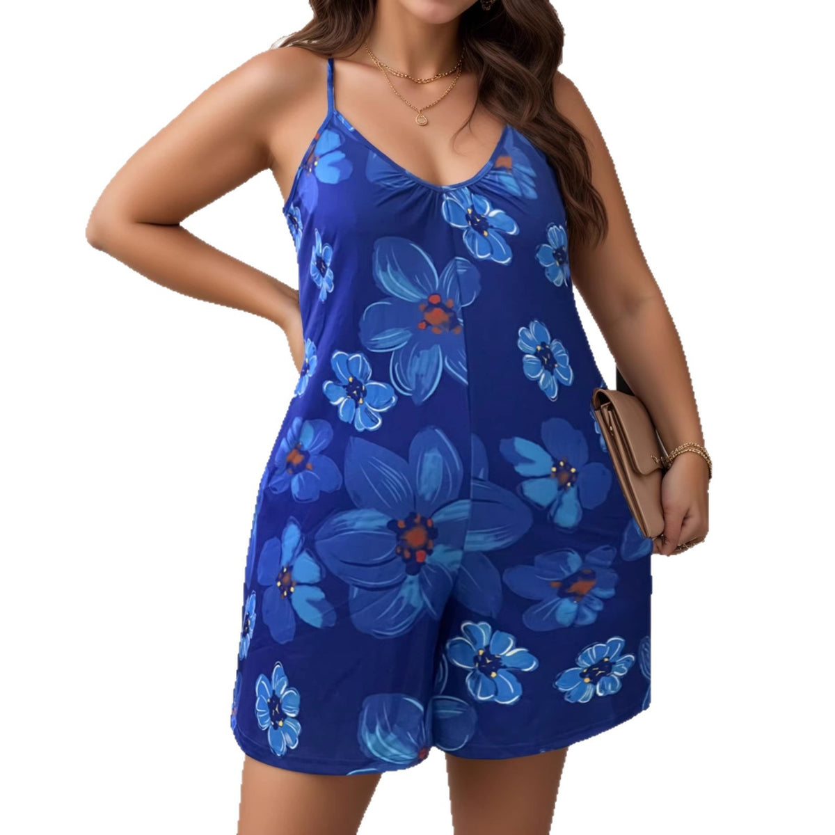 A plus-size model wears a blue floral print cami jumpsuit with thin straps and shorts.