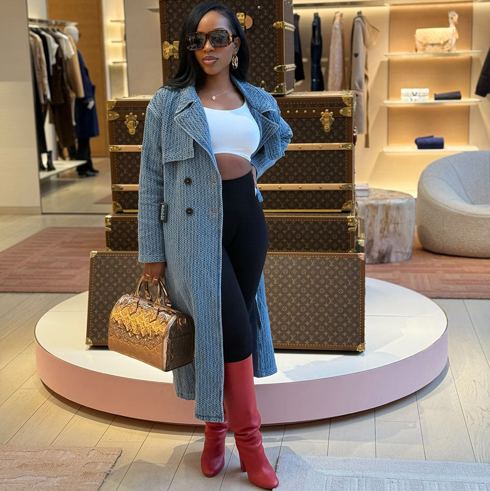Women's loose denim trench coat by eprolo with long sleeves, belt, and street style design, shown hanging on a hanger.