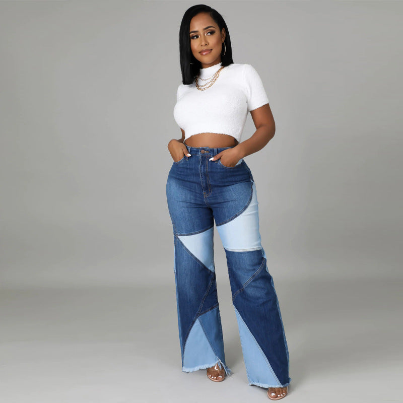 A woman wears patchwork-style blue denim wide-leg jeans with a white short-sleeve crop top.