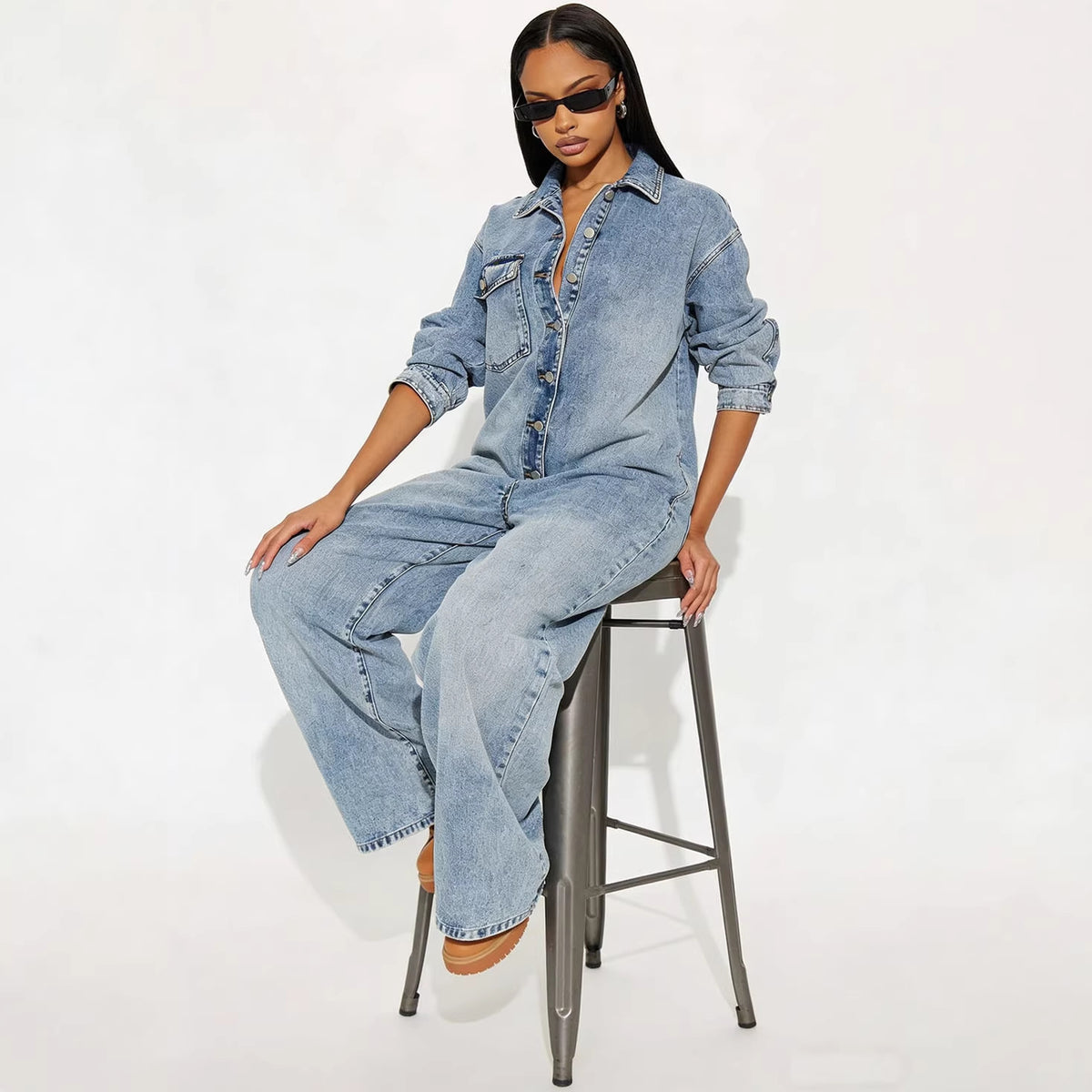 Women's long sleeve denim jumpsuit with button-front closure by Plush Fashion Hub, featuring a casual, stylish fit.