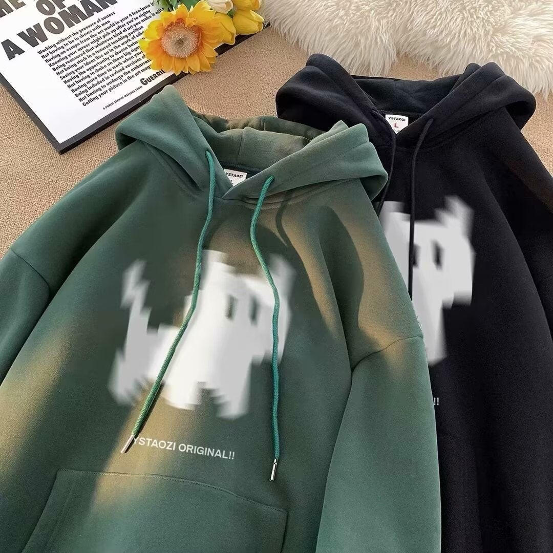 Dark green and black fleece hoodies featuring a blurry white pixelated graphic and matching drawstrings.