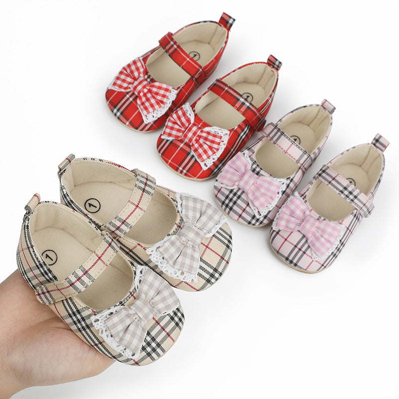 Four pairs of plaid fabric baby Mary Jane shoes in red, beige, and pink, each with a lace-trimmed bow.
