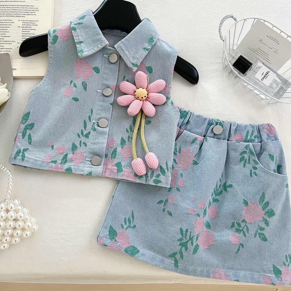 Light blue denim vest and skirt set with pink floral pattern, front buttons, and detachable pink flower brooch.