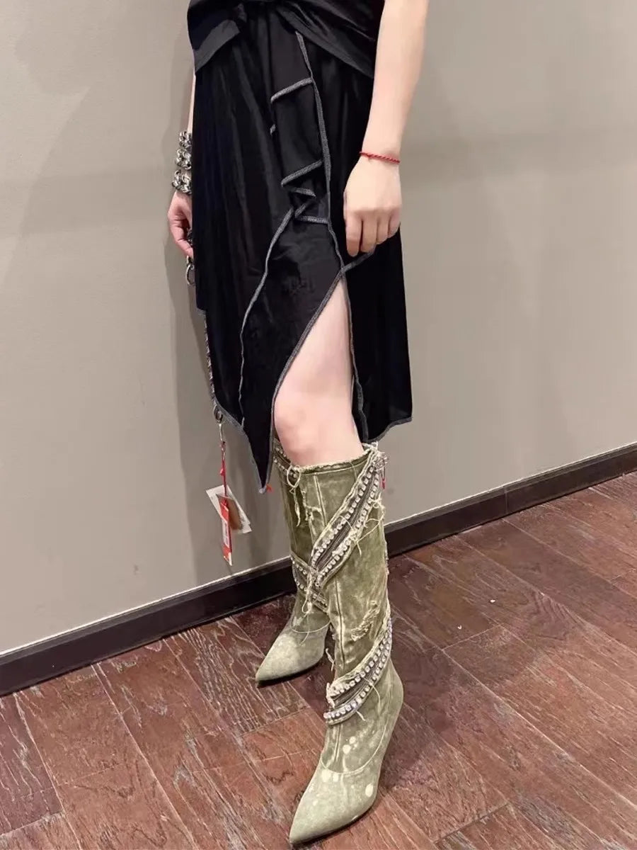 Olive green denim boots, distressed style with frayed edges and embellished straps, worn with black dress.