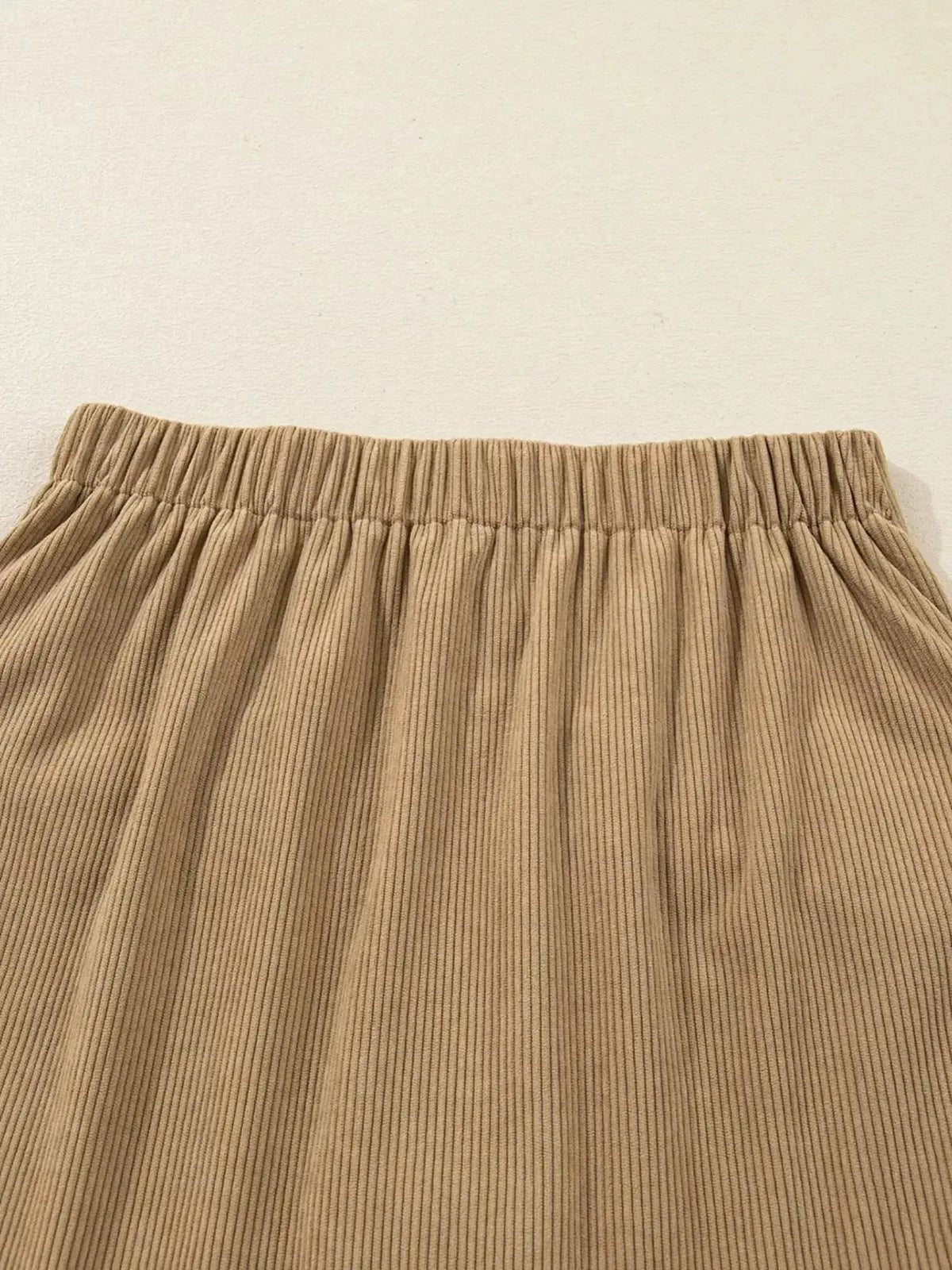 Women’s high-waisted corduroy mini skirt with button-front detail by Plush Fashion Hub, showcasing the textured fabric and stylish design.