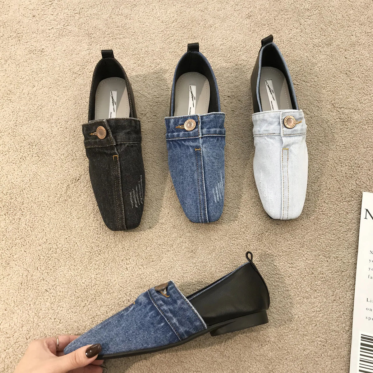 Four denim and leather flat loafers in dark gray, medium blue, and light blue with a decorative button.