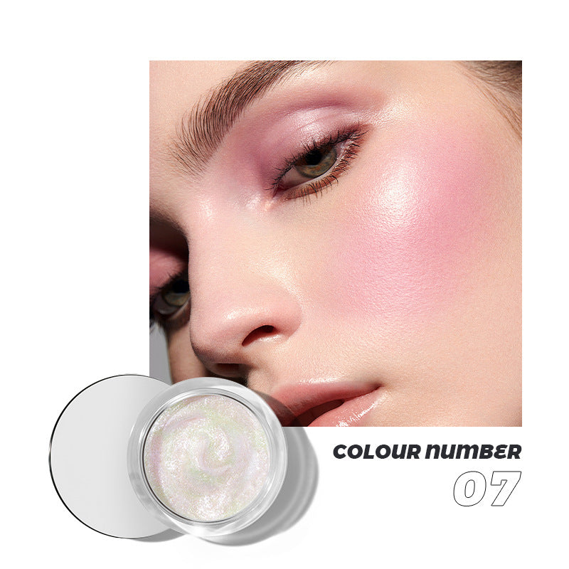 A round glass jar of shimmery pink highlighter cream, labeled colour number 07, beside a model with pink makeup.