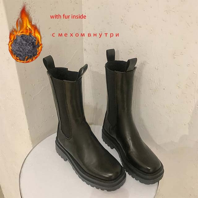 Black leather mid-calf Chelsea boots with chunky lug soles, elastic side panels, and pull tabs.