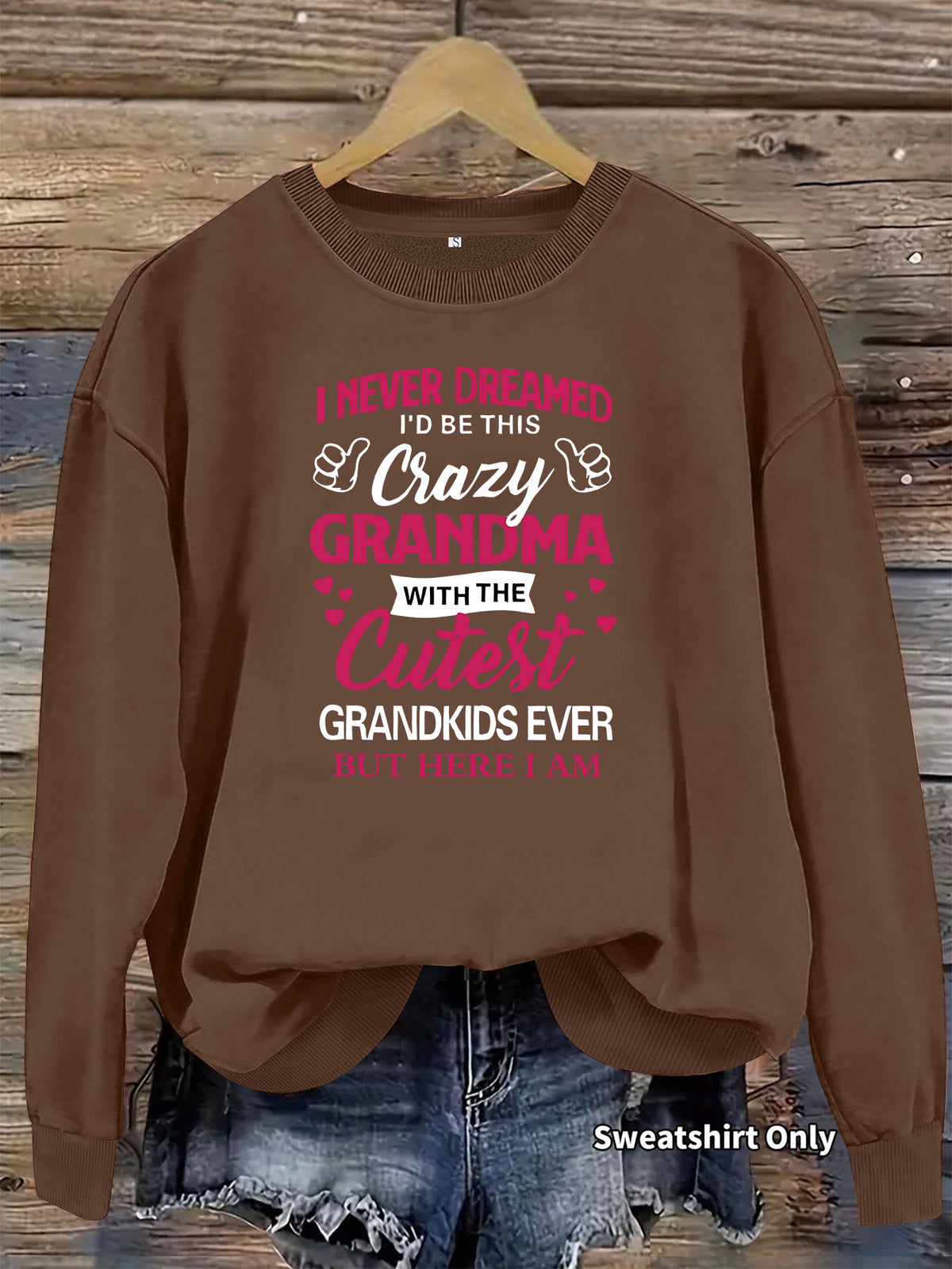 Brown crewneck sweatshirt with pink and white text reading "Crazy Grandma" and thumb-up icons.