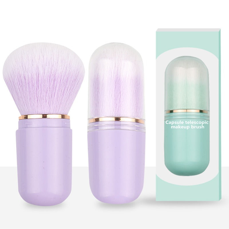 Light purple capsule telescopic makeup brush with soft bristles and gold accent next to its packaging box.