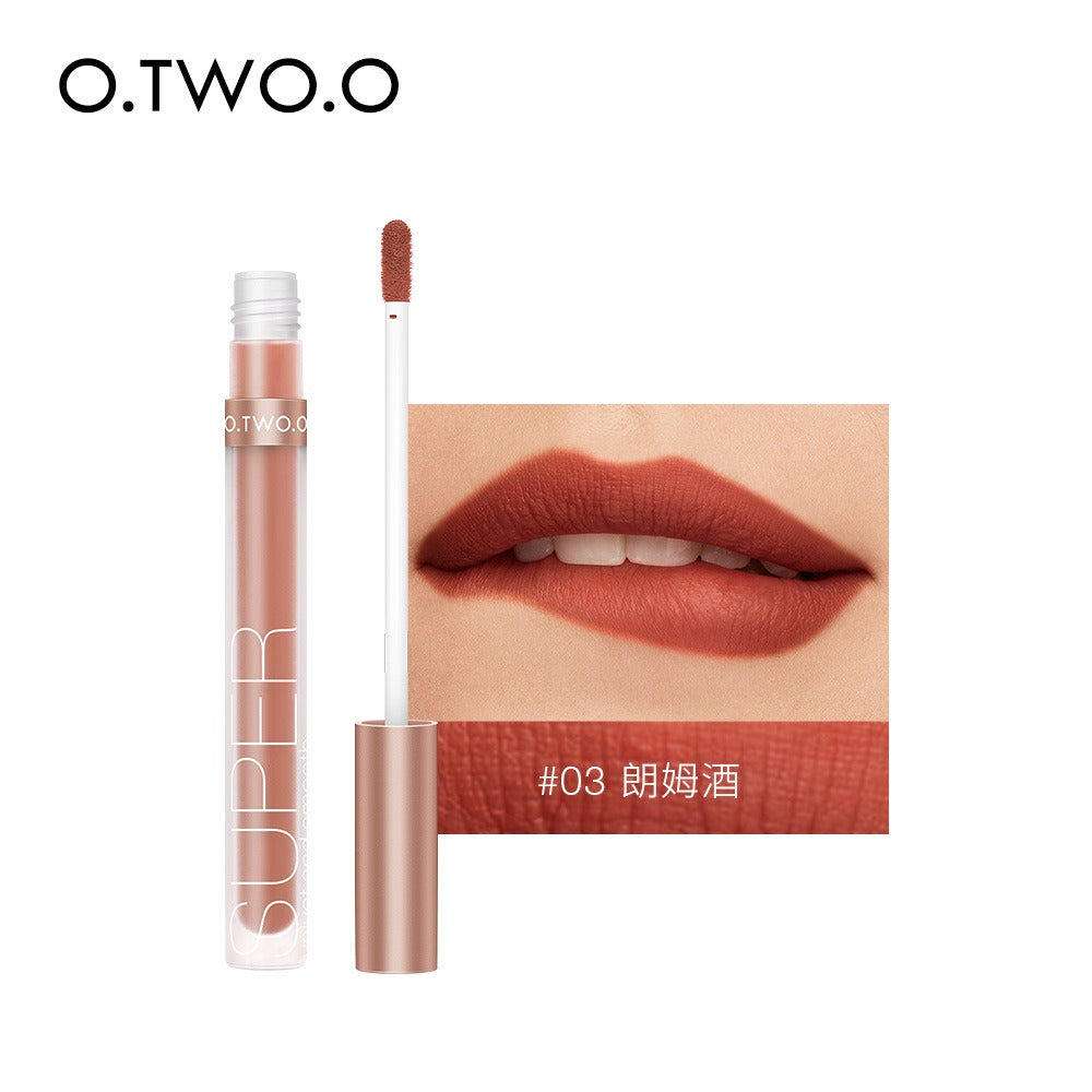 O.TWO.O liquid lipstick in a translucent plastic tube with a metallic pink cap, and a matte terracotta shade swatch.