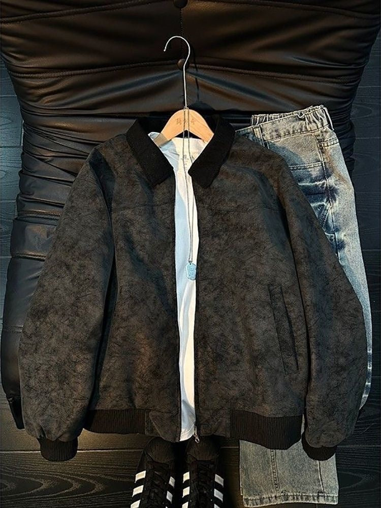 Black faux-suede bomber jacket with ribbed collar, cuffs, and hem, over a white t-shirt and blue jeans.