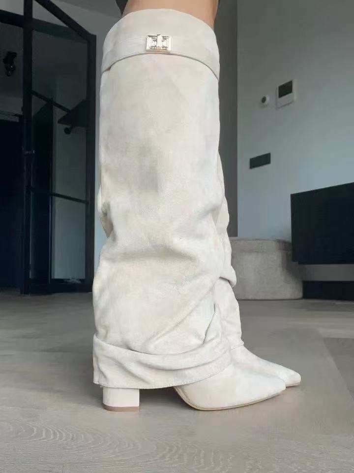 Beige suede slouchy knee-high boots with pointed toes, block heels, and buckled straps at the top.