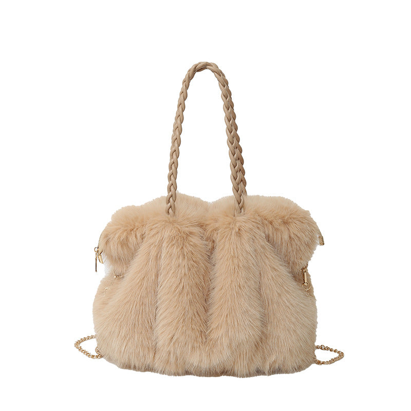 Beige faux fur handbag with a braided strap and gold chain detail on a white background.