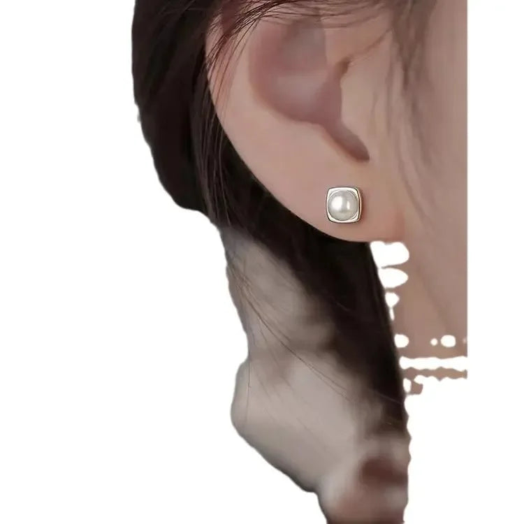Sterling silver pearl stud earrings featuring minimalist geometric design, elegant jewelry for women.